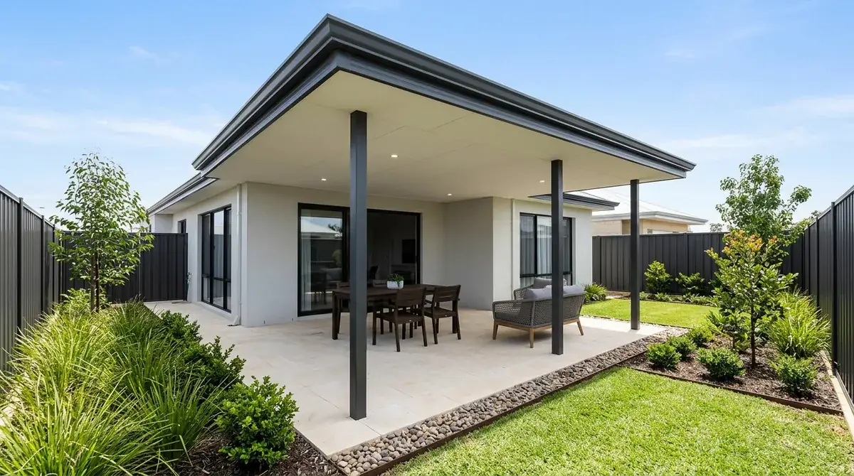 A flat patio roof over paving in a newer Baldivis estate backyard, dark Colorbond fencing on three sides and no mature trees anywhere in the yard.