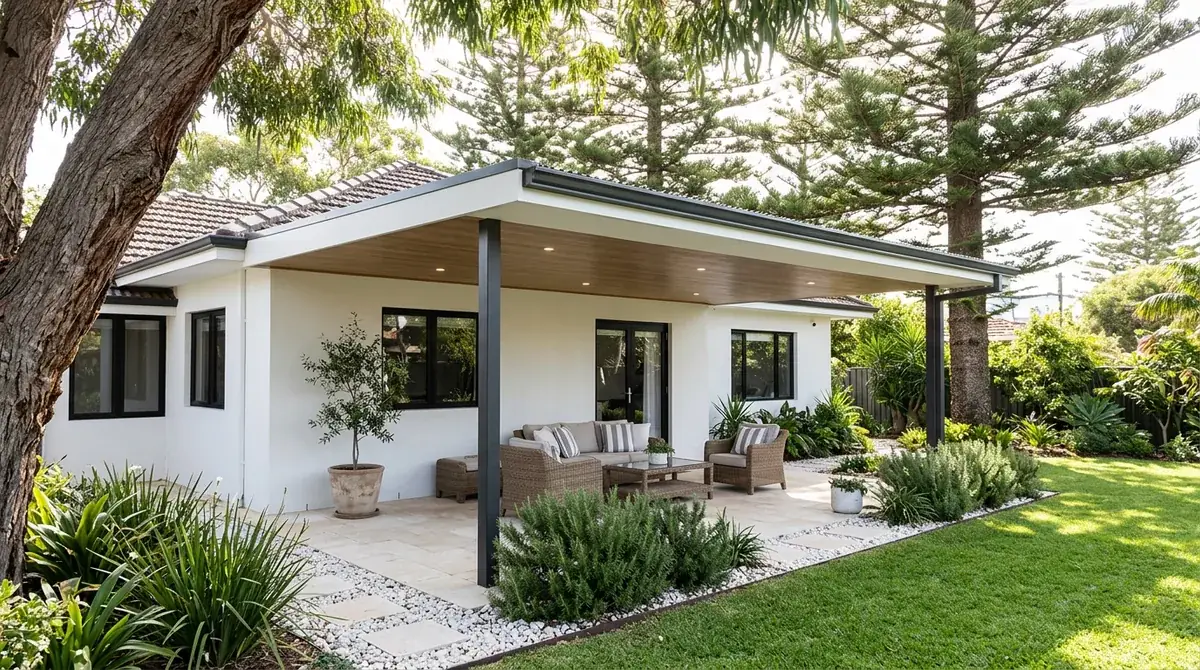 A low flat patio roof behind a Cottesloe bungalow, Norfolk Island pines standing over it and the fall running to a gutter you can reach with a ladder