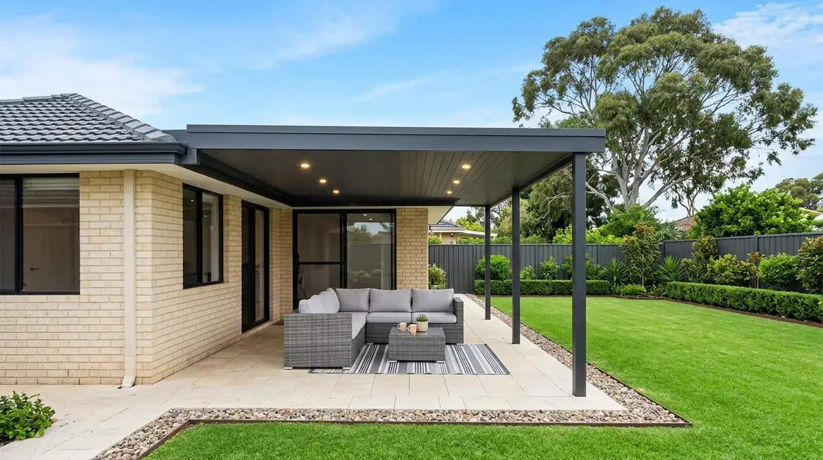 Flat Colorbond patio over the back yard of a 1970s brick and tile home in Thornlie, set only as deep as the outdoor setting so winter sun still reaches the rear glass