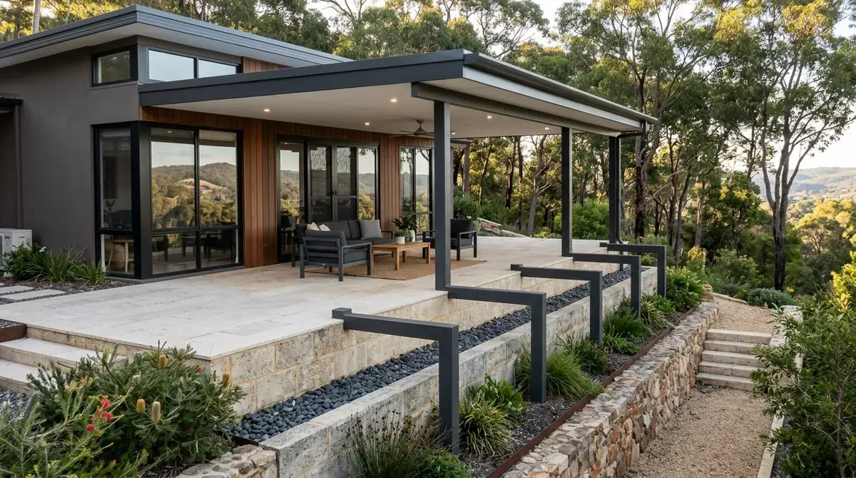 Flat Colorbond patio roof held level across a sloping Kalamunda block, posts of varying length stepping down the fall with mature jarrah and marri around it